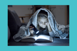 A child reads a book by flashlight under their bedcovers