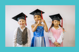 Three young children are posed wearing graduation caps