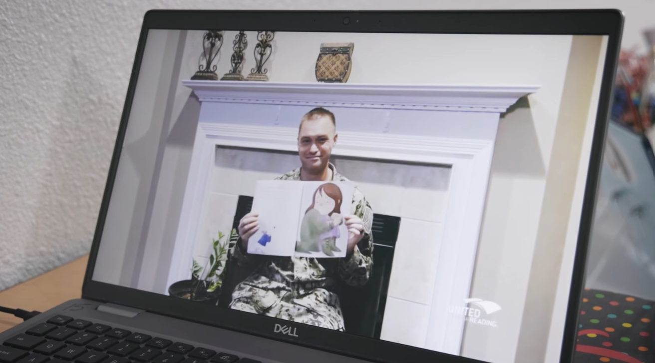 Video of a service member reading a story on a laptop