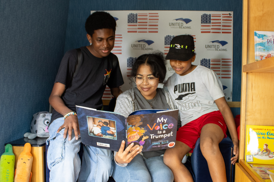 The children reading a book int he Mobile Story Station