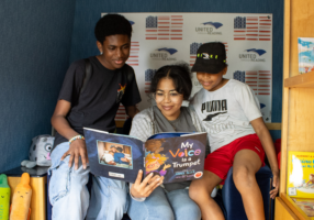 The children reading a book int he Mobile Story Station