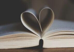 An open book whose pages form a heart shape