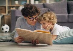 Woman reading book to a happy child