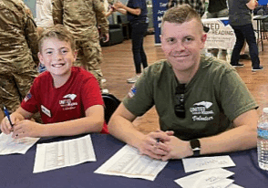 Service member and son smiling